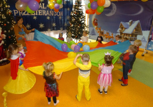 Dzieci podrzucają balony rozłożone na chuście animacyjnej.